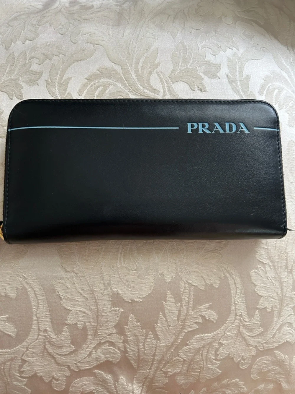 7013. Authentic Prada Black Leather Zip Wallet w/Turquoise Logo Detail & COA.